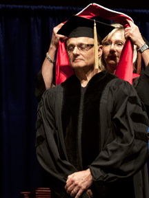 Captain Donald Bittner, M.D. '77 is hooded by Newman University Board of Trustees Chair Linda Snook '77 during the Spring 2013 Commencement ceremony. Bittner received a Doctor of Humane Letters, honoris causa, for his service to the people Afghanistan, Europe, California and Newman University.