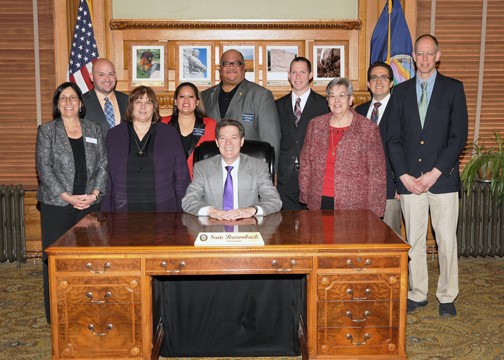 Representatives from Newman University had an opportunity to meet Kansas Gov. Sam Brownback while in Topeka to attend the approvals of the House and Senate resolutions. Pictured with Brownback (seated) are, l-r: Newman President Noreen M. Carrocci, Ph.D.; Newman student Jonathan Albers; Associate Vice President of Academic Services and Student Development Rosemary Niedens; Rep. Ponca-We Victors; Rep. Roderick Houston; Newman student Chase Blasi; Director of Mission Effectiveness and Archives Charlotte Rohrbach, ASC,; Associate Professor of Theology Joshua Papsdorf, Ph.D., and Associate Professor of History Kelly McFall, Ph.D.