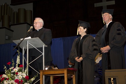 The Most Rev. Eugene Gerber, Bishop Emeritus of the Wichita Diocese, reads the proclamation awarding  an honorary degree to Katy and Patrick O'Shaughnessy.