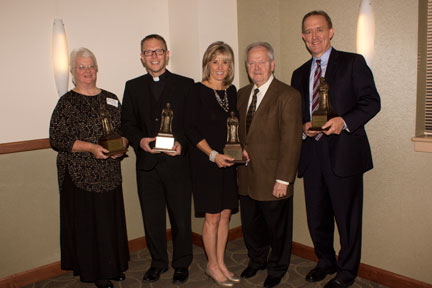 Among those honored at the Nov. 5 Beata Benefactors Banquet were members of the 1933 Society, which honors donors who have given a cumulative amount of $1 Million to Newman University. Pictured are, l-r: U.S. Region Leader Barbara Hudock, ASC, representing the Adorers of the Blood of Christ; Father Mike Simone, representing the Catholic Diocese of Wichita; Dana and Larry Fugate; and Via Christi CEO Jeff Korsmo, representing Via Christi Health. Each received a statuette of the university’s namesake Blessed John Henry Cardinal Newman. 1933 Society members not pictured are Marilyn and John Dugan; Joan Eck; Kathy and Patrick O’Shaughnessy; the I.A. O’Shaughnessy Foundation, and the J.E. and L.E. Mabee Foundation.