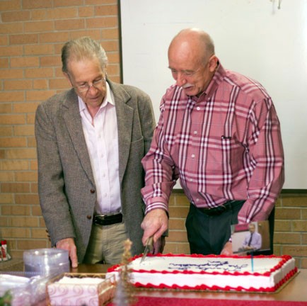 Professor of Education Don Hufford, Ph.D., looks on as Associate Dean and Associate Professor of Education Steve Dunn, Ed.D. cuts the cake at Hufford's Dec. 8 farewell party