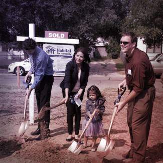 Newman University Student Government President Brandon Golhofer (left) and Newman University Faculty Senate President John McCormick (right) break in the build with Blanca Fernandez and her daughter. Photo credit: Christopher Riggs, Catholic Advance