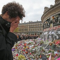PARIS, FRANCE - NOVEMBER 16: A man weeps for a lost friend as people gather to observe a minute-silence at the Place de la Republique.