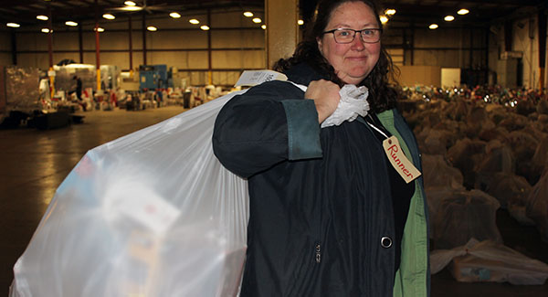 Sarah Evans, Professor of Biology at Newman University, runs gifts from the back of the warehouse to waiting families. 