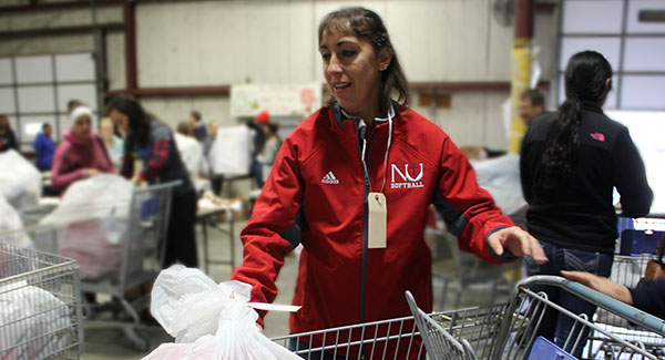 Janice Esses, Newman University head softball coach, loads a cart with Angel Tree gifts.