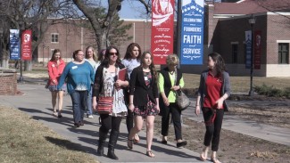 High school students and family members join Newman Ambassador Maureen Hogan on a campus tour.