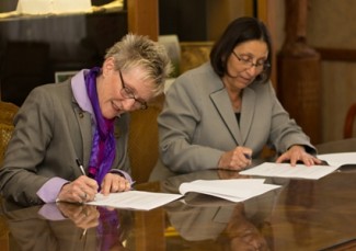 Newman President Carrocci and Butler President Krull sign an agreement March 11 in the Heritage Room on the Newman campus. 