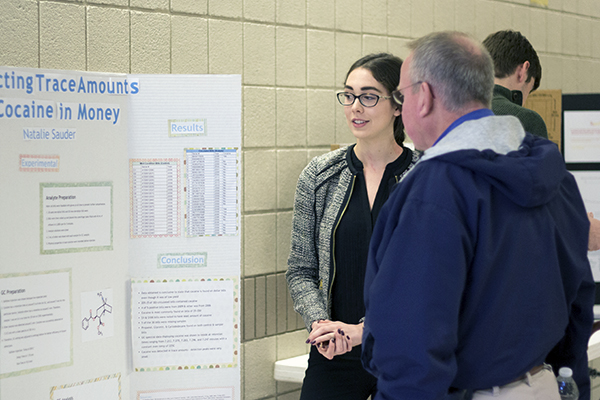 Natalie Sauder explains her project during the poster session of Scholars Day.