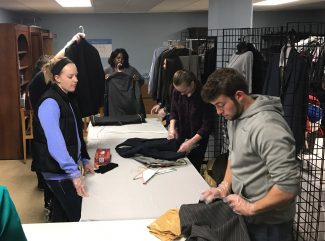 Students organize clothing at Catholic Charities