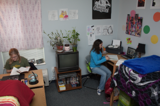 Two students personalize their room in Carrocci Hall.