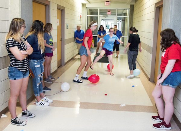 A T&T class plays an icebreaker game involving balloons.