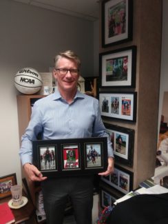 Johnston displays photographic souvenirs of Ironman competitions in his Sacred Heart office.