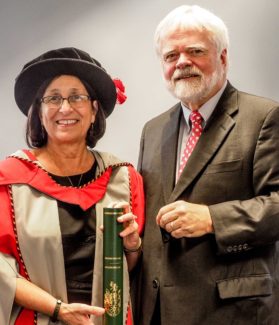 Noreen M. Carrocci, Ph.D., poses with husband Bob Benson after receiving her honorary degree from Newman University, Birmingham.