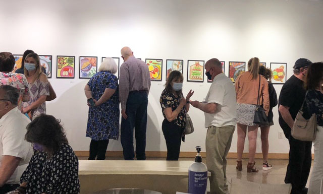 Art viewers peruse the four students' senior artwork in the Steckline Gallery.