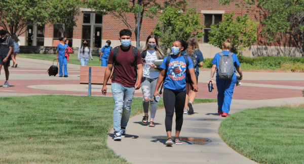 Students walk on a sidewalk on campus.