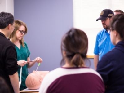 Instructors and fellow students learn respiratory care technique during student demonstration