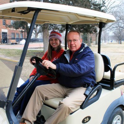 Director of Campus Security Mo Floyd drives a student on crutches to class on his golf cart.