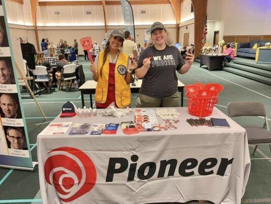 Madison McCollum (right) mans a Pioneer booth at an event in Oklahoma.