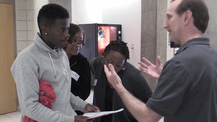 John Vogt talks to a student and his family on Accepted Students Day.