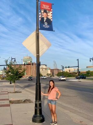 Melanie Flanagan stands beneath her sponsored Kansas Honor Banner in the Delano district in downtown Wichita.
