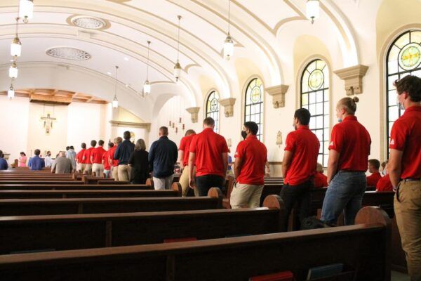 Members of the men's baseball team wear their red shirts for Mass in St. John's Chapel.
