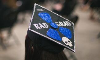 Graduate wears a decorated "2021 Rad Grad" graduation cap.