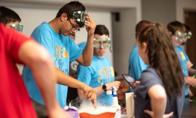 High school students conduct experiments during a STEM program at Newman University.