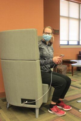 Student Maria "Mia" Schippers tries out one of the new grey chairs, complete with USB ports and outlets.