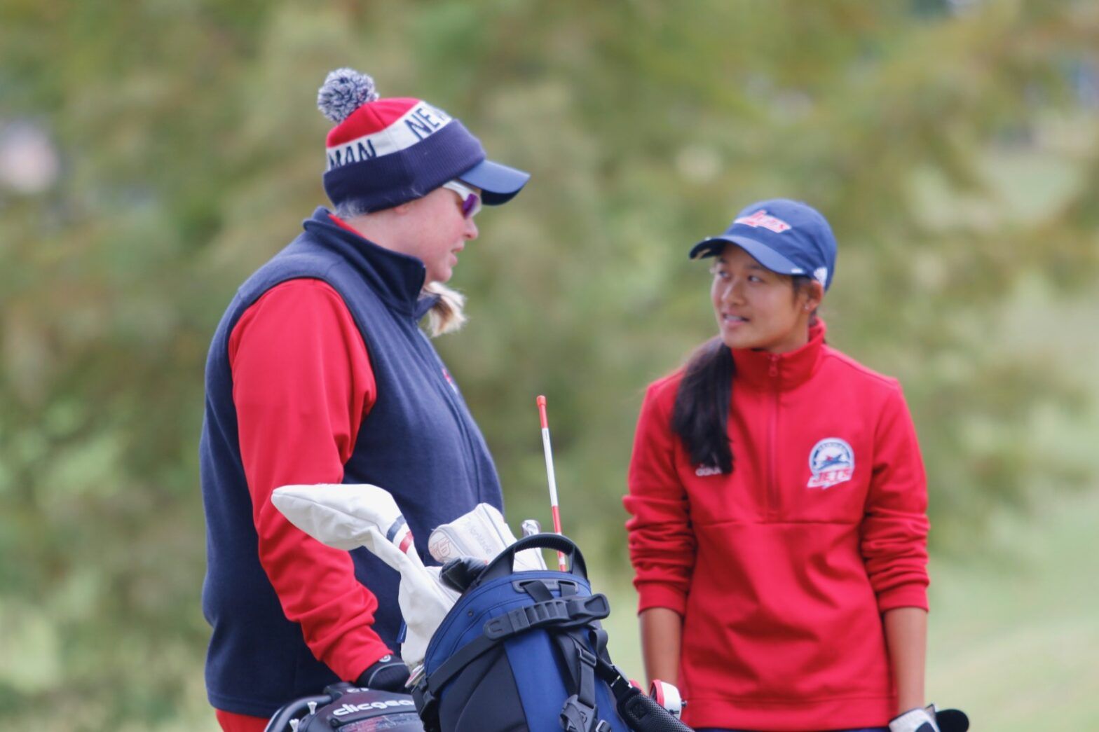 Newman golf coach Taryn Torgerson talks with freshman Alivia Nguyen