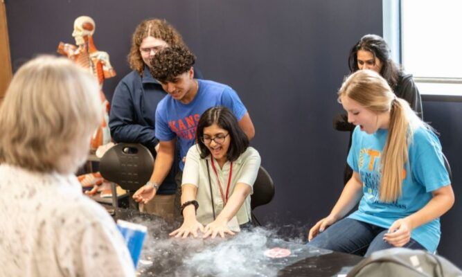 Students conduct an experiment with a professor during the 2021 Newman University ISSP camp.