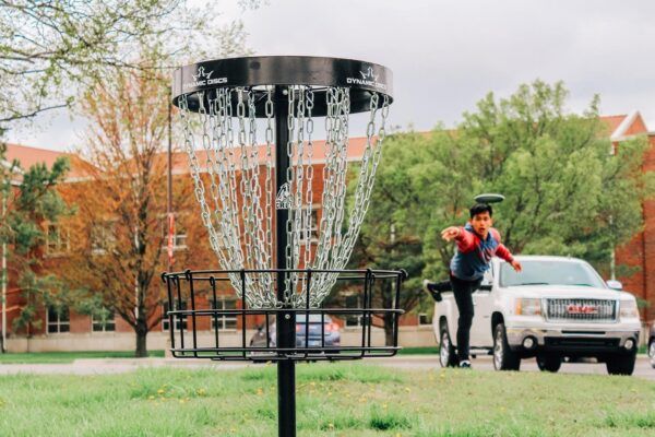 Steven Nguyen plays disc golf on the Newman University campus.