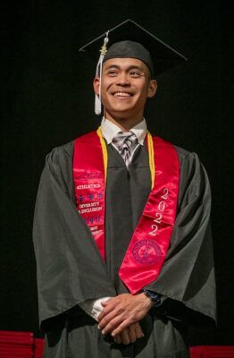 Steven Nguyen smiles to his family from the Newman commencement stage on May 6 at the Hartman Arena.