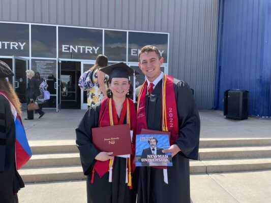 (Left to right) Madeline Schnieders and Tejay Cleland pose outside Hartman Arena following the 2022 commencement ceremony.