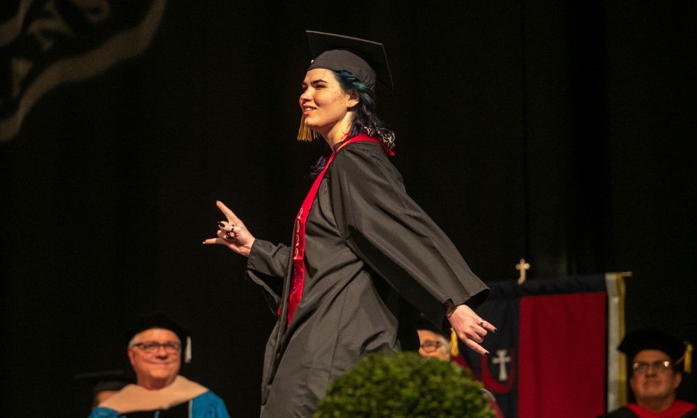 Alice Miles, a 2022 social work graduate of Newman University, walks across the stage to collect her degree.