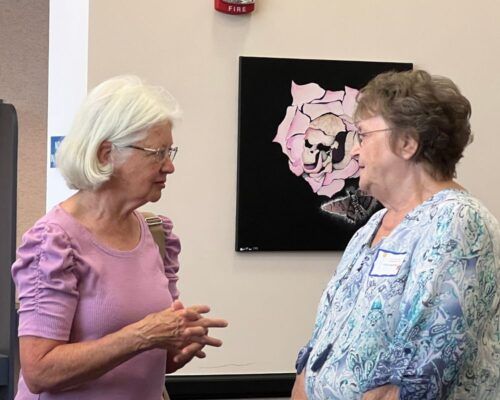 Classmates Linda Zollars (left) and Gloria Spraberry (right) reconnect at the Sacred Heart Academy luncheon.