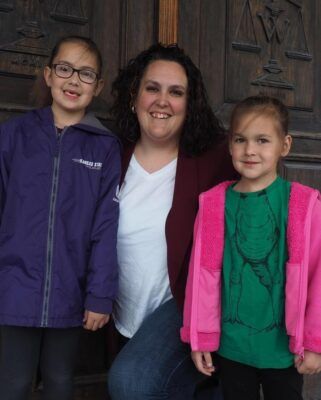 Kate Langworthy proudly stands with her two children outside Washburn University, where she recently completed law school.