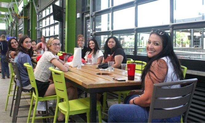 Dean of Students Sara Mata (far right) chats with students of the Elevate to Excellence program over lunch at Chicken N Pickle.