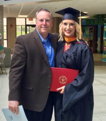 Paige Puryear poses with her father at her Newman University graduation.