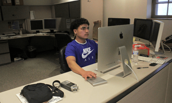 Joshua Robles writing an article at his desk