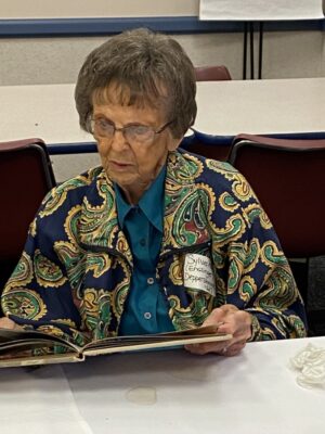 Sylverina browses a Sacred Heart Junior College (SHJC) yearbook.