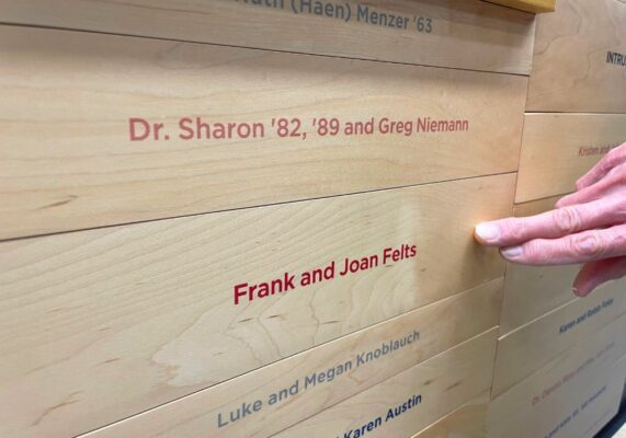Joan Felts points to her name on the donor wall in the Bishop Gerber Science Center.