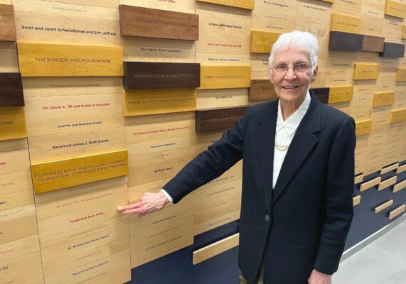 Joan Felts points to her name on the donor wall in the Bishop Gerber Science Center.
