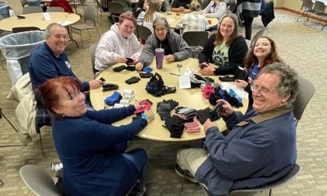 Staff, faculty and students help package socks for The Lord's Diner in Wichita.