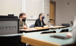 (Left to right) Newman Professor Jamey Findling and Virginia Eubanks discuss Eubanks' work with students during an ethics class.