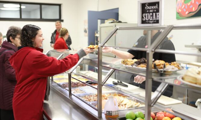 Emily Simon picks up a plate of breakfast from a server at the Mabee Dining Center.