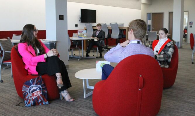 Students talk while awaiting their interviews at Newman University.
