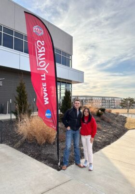 Students Bailor Harris and Sajulga stand in front of an MIAA banner in Kansas City, Missouri.