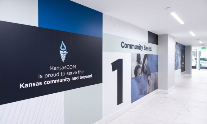 A wall mural at the Kansas College of Osteopathic Medicine reads "KansasCOM is proud to serve the Kansas community and beyond."