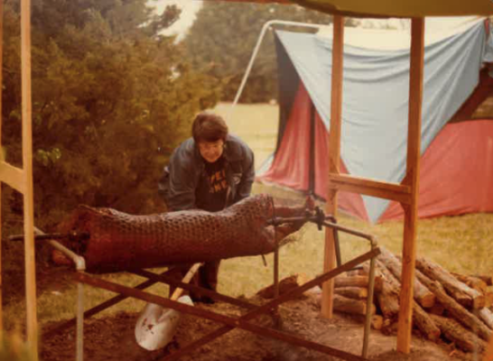 A Pi Gamma Mu member helps prepare the pig roast during a Newman Renaissance Faire in the early 90s. (Courtesy photo)