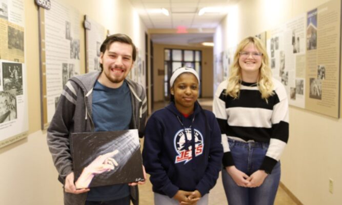 Kaylee, Elginique, and John pose for a picture.